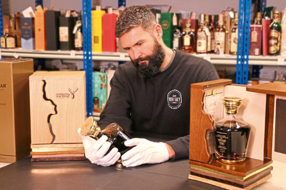 Team members of Just Whisky checking bottles’