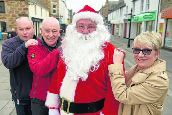 Santa came early to Dingwall yesterday ahead of the town's Christmas Lights switch on following work done in the town to erect his years lights.  Also in the photograph are Andrew Macivor, community councillor, Jack Shepherd, Chairman of Dingwall Community Council and Di Agnew Highland Council Ward Manager. Picture by Sandy McCook