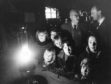 An oil lamp casts a gentle glow on the faces of Corgarff children awaiting the hook-up of the village to the National Grid.