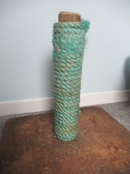 A cat-scratching post made of rope and wood