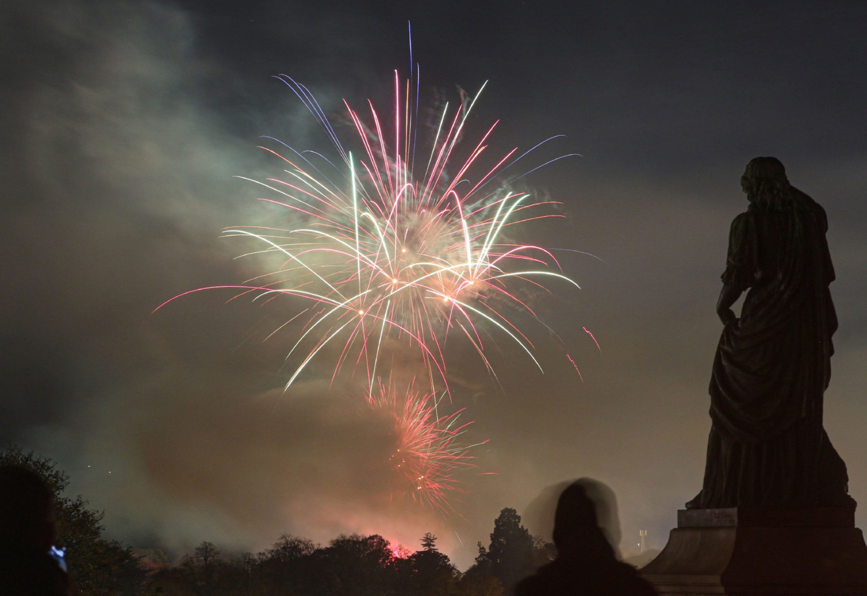 Fireworks at Bught Park, as seen from Inverness Castle with the statue of Flora MacDonald in the foreground.