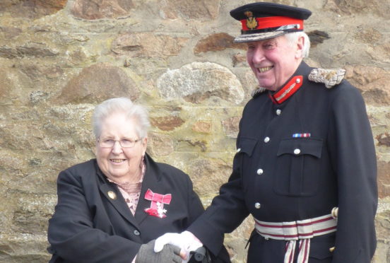 Mrs Morris receives her MBE from James Ingleby, Lord Lieutenant of Aberdeenshire.