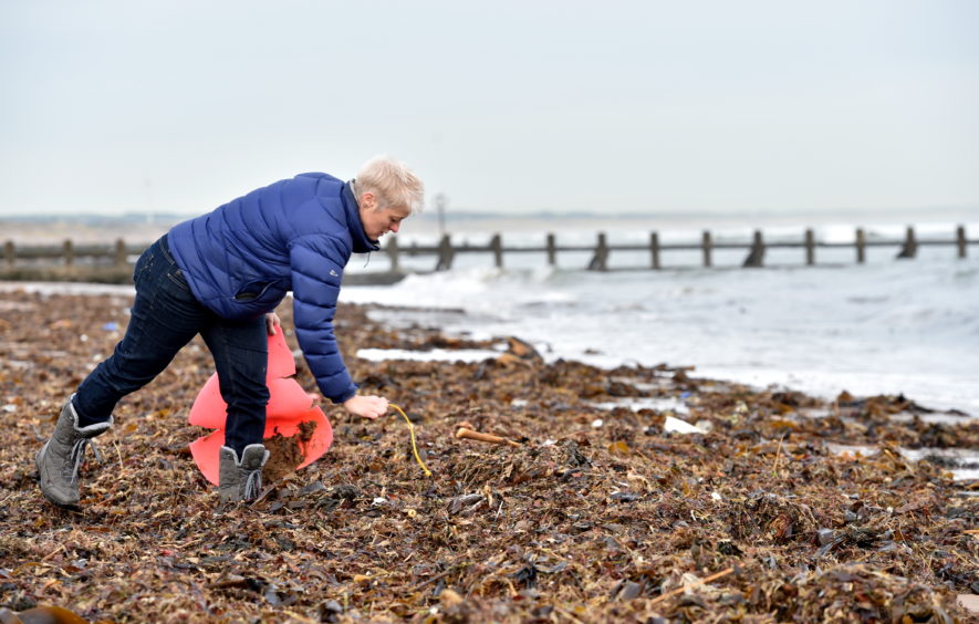 A pile of plastic has washed up on the beach and a concerned resident is worried it will be washed back into the sea when the tide comes in.
Pictured is Gail Dicksman picking up some of the rubbish washed up on Aberdeen Beach.
Pictured on 19/11/2019
CR0016578