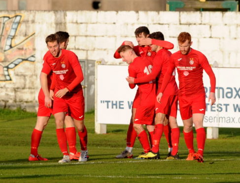 Jordan MacRae is embraced by Andrew Macrae (10).