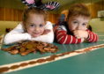 Thea McCulloch and Ethan Murray of Lossiemouth lend a hand to lay out the hundreds of yards of coins on the floor of Lossiemouth Community Centre. Picture by Sandy McCook