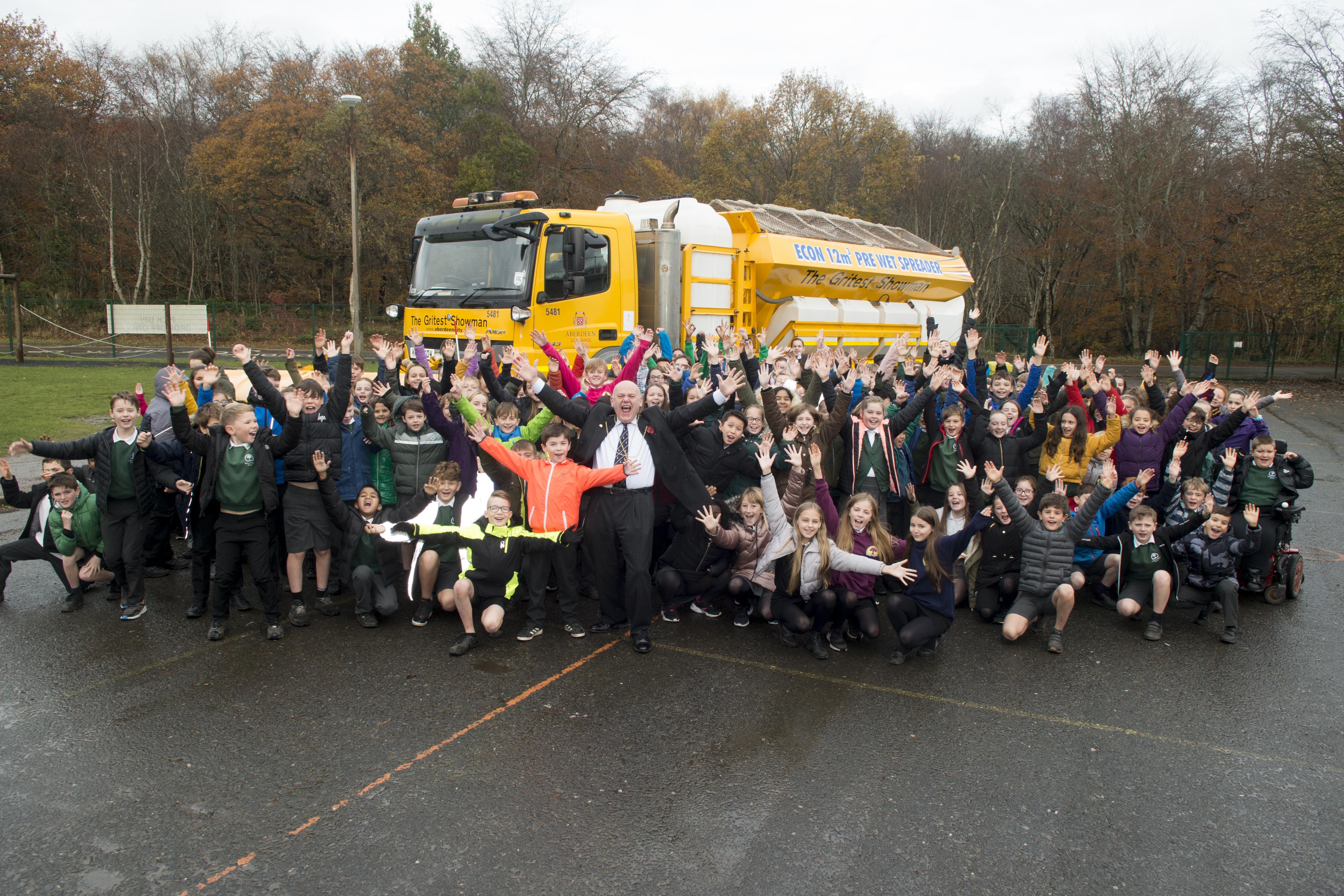Pupils of Cults Primary with the big 18-wheel gritter which has been named with their entry – The Gritest Showman. Pictured at the front are Lord Provost of Aberdeen Barney Crockett and P6 pupil, 10-year-old Oliver Ironside, who came up with The Gritest Showman suggestion for the school