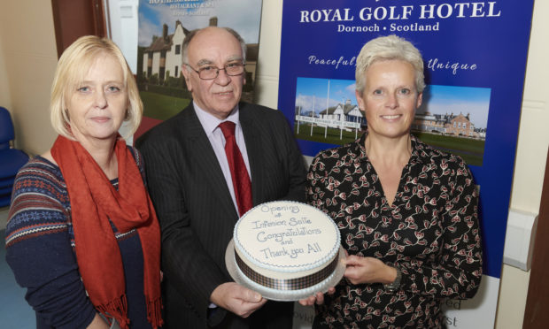 Jill Falconer, Jackie Milburn, clinical nurse manager for NHS Highland chronic pain management clinic, hold the celebration cake, watched by David Sutherland, whose family trust contributed to the new facility opened at Lawson Memorial Hospital.