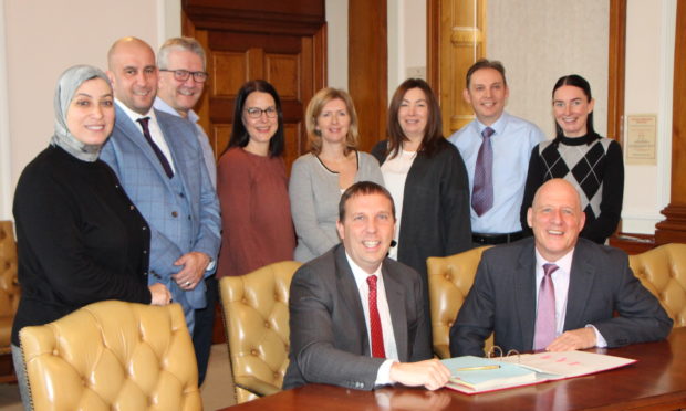 Mike Clayton (seated left) with Jim Allison (seated right) and members of the laboratory team.