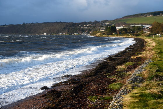 Stormy seas with a strong south west gale batter the shoreline  of the Inverness Firth at Fortrose on the Black Isle.