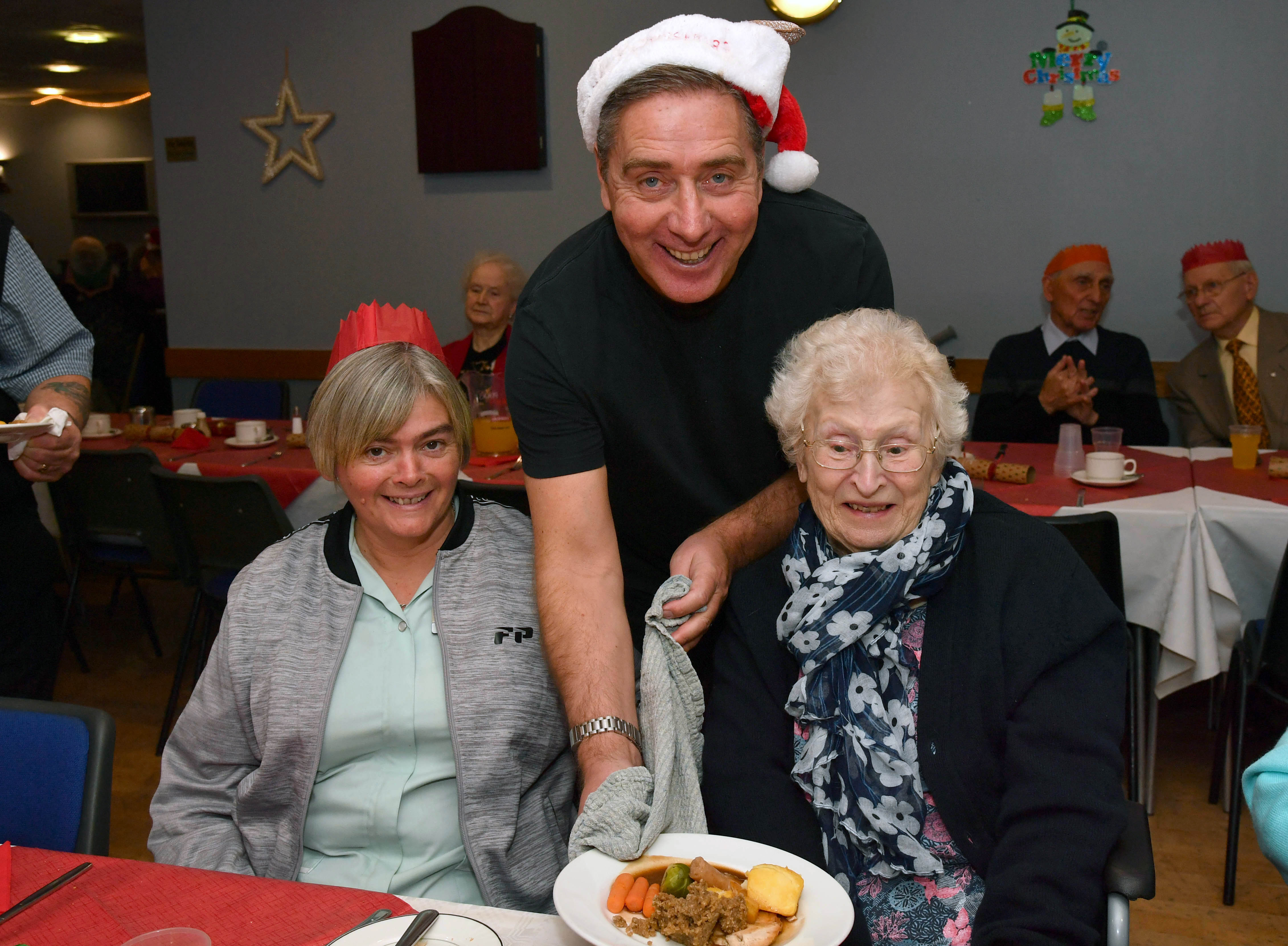 PETERHEAD FC MANAGER JIM MCINALLY SERVES CHRISTMAS DINNER TO  MORAG MCBAIN (L) AND JENNY RITCHIE AT THE CLUBS ANNUAL LUNCH FOR LONELY PEOPLE.