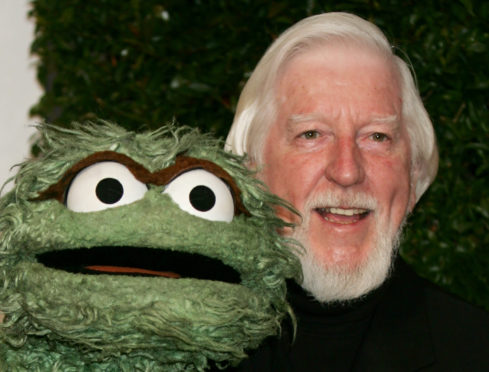 FILE - In this Thursday, April 27, 2006, file photo, Caroll Spinney, right, who portrays "Sesame Street" characters Oscar The Grouch, left, and Big Bird, arrives for the Daytime Emmy nominee party at the Hollywood Roosevelt Hotel in Los Angeles. Spinney, who gave Big Bird his warmth and Oscar the Grouch his growl for nearly 50 years on "Sesame Street," died Sunday, Dec. 8, 2019, at the age of 85 at his home in Connecticut, according to the Sesame Workshop. (AP Photo/Reed Saxon, File)
