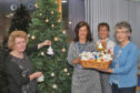 Busy Hands group representatives Mary Cameron (left) and Roseanne Youngson (right) visited Chalmers Hospital, Banff, with a basket full of 50 angels which were accepted by Brenda Smart (centre left), area support manager, and Carlynn McLeod, clerical officer