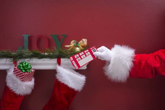 Santa putting a present in a stocking.