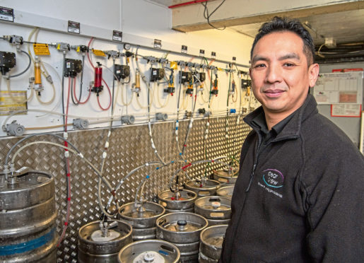 Wai Tsang at work in the beer cellar.