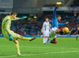 Jermain Defoe of Rangers tries to block a clearance from Ross County goalkeeper Nathan Baxter.