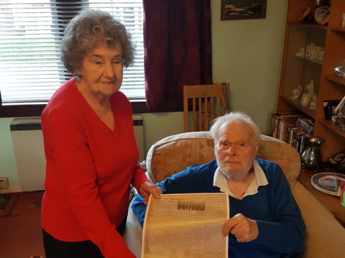 Ronald Halliday and his wife Mary holding a copy of The P&J's coverage of a VE Day parade in 1945