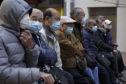 Elderly men sit at a park wearing face masks in Hong Kong, Thursday, Jan. 30, 2020. Hong Kong cut off rail service to mainland China at midnight on Wednesday to Thursday to try to stop the spread of the coronavirus to the city.