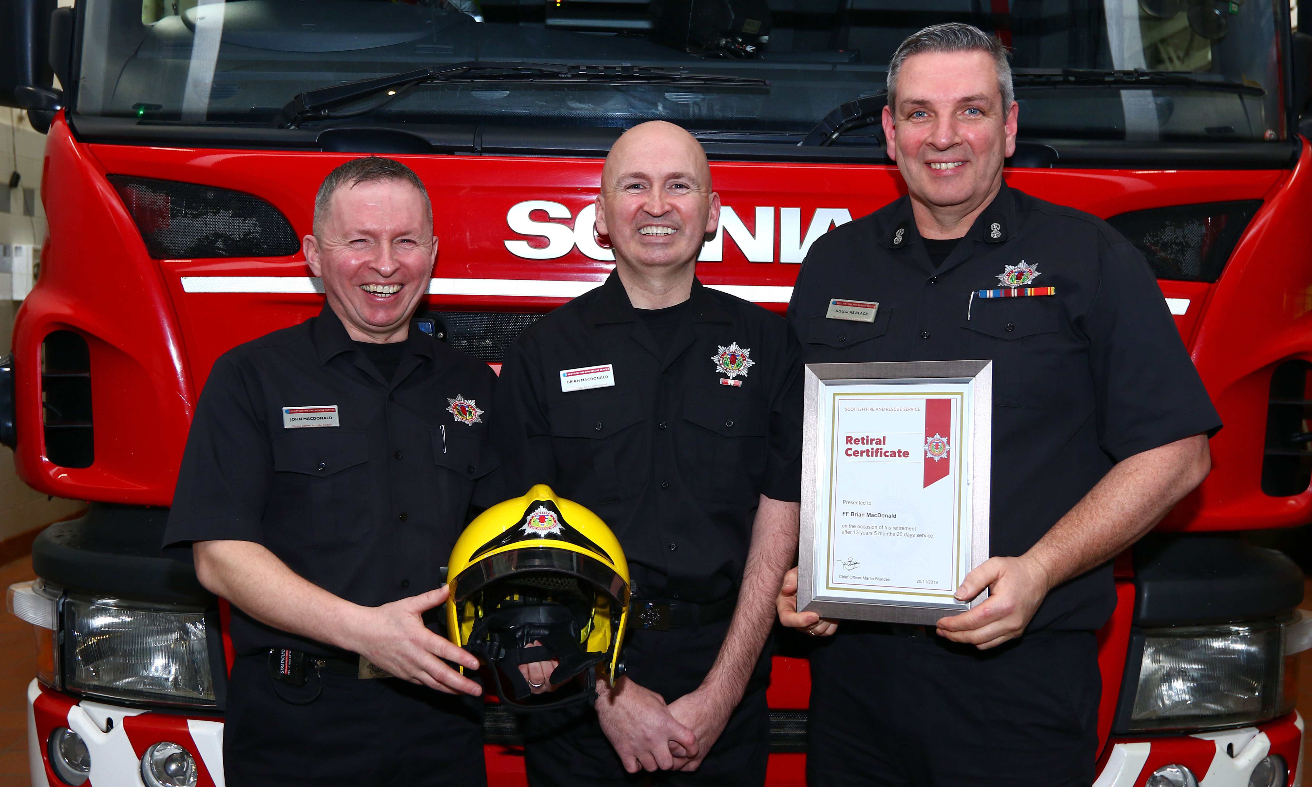 Brian MacDonald, centre, pictured receiving his retirement certificate from his brother John B MacDonald and Oban watch commander Dougie Black.