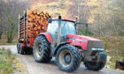 Tractor carrying timber.