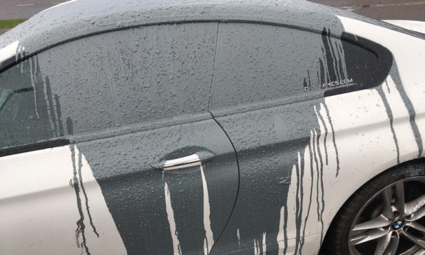 The white BMW 6 Series covered in grey paint.