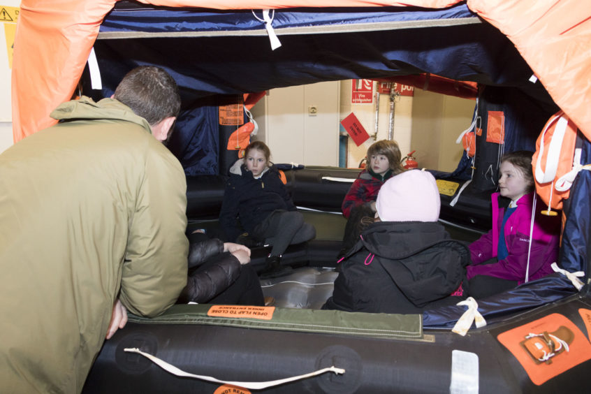 Engineers in the Survival Equipment Section show the youngsters some of the live saving equipment used by pilots, including the emergency life raft.