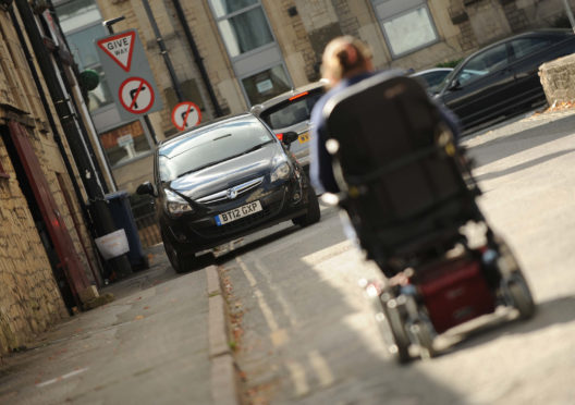 Mandatory Credit: Photo by Paul Gillis/Shutterstock (8556754b)
Disabled woman unable to use footpath due to sidewalk parking, car parked on double yellow line.
Disabled woman unable to use footpath due to car parked on pavement, UK - 14 Oct 2015