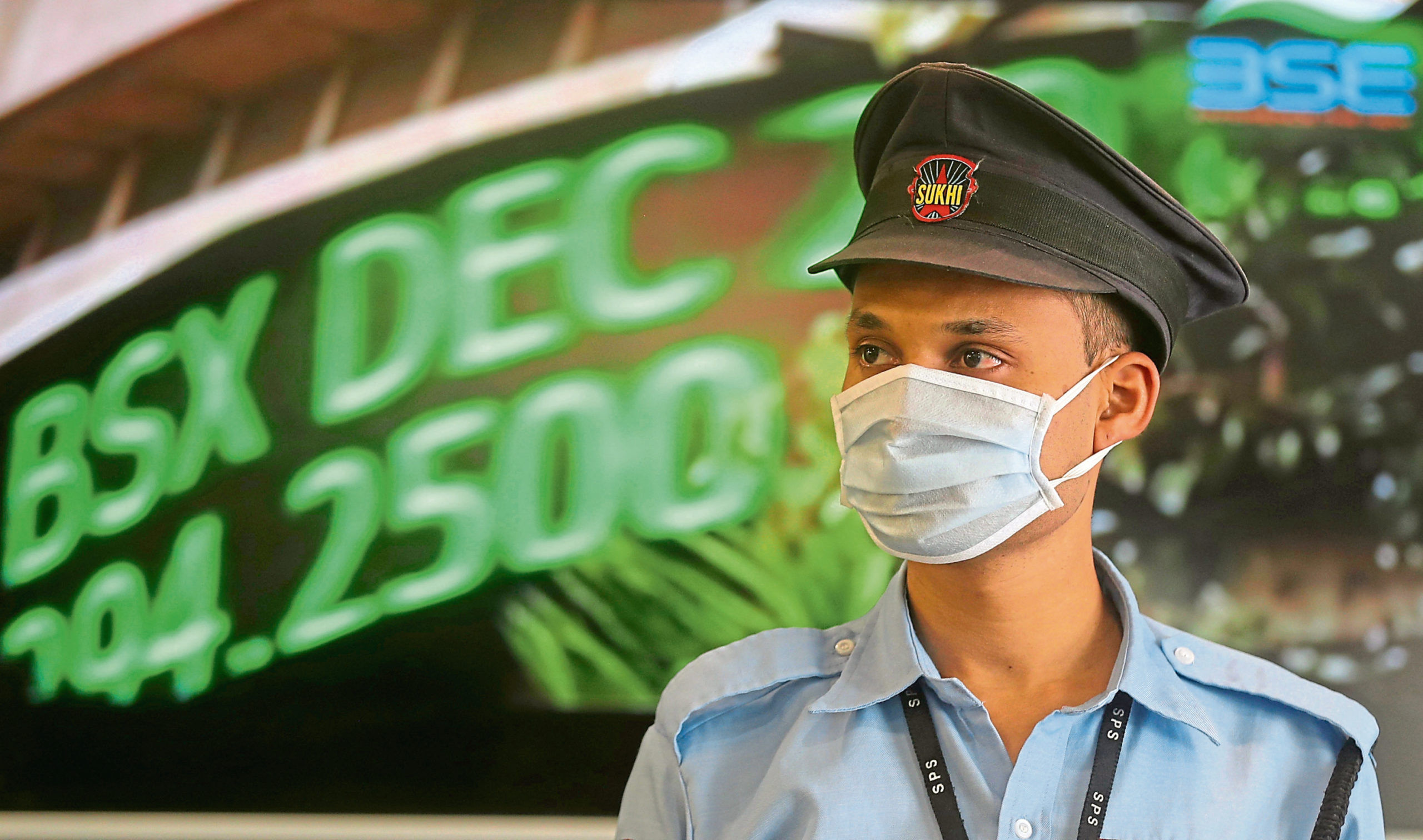 A security guard wearing a mask as a precaution against the new coronavirus stands at the Bombay Stock Exchange (BSE) building in Mumbai, in Mumbai, India, Monday, March 16, 2020. For most people, the new coronavirus causes only mild or moderate symptoms. For some, it can cause more severe illness, especially in older adults and people with existing health problems. (AP Photo/Rafiq Maqbool)