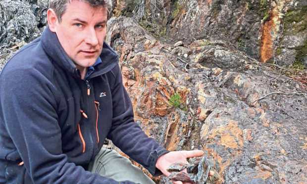 Gavin Berkenheger, managing director of GreenOre Gold, taking rock samples