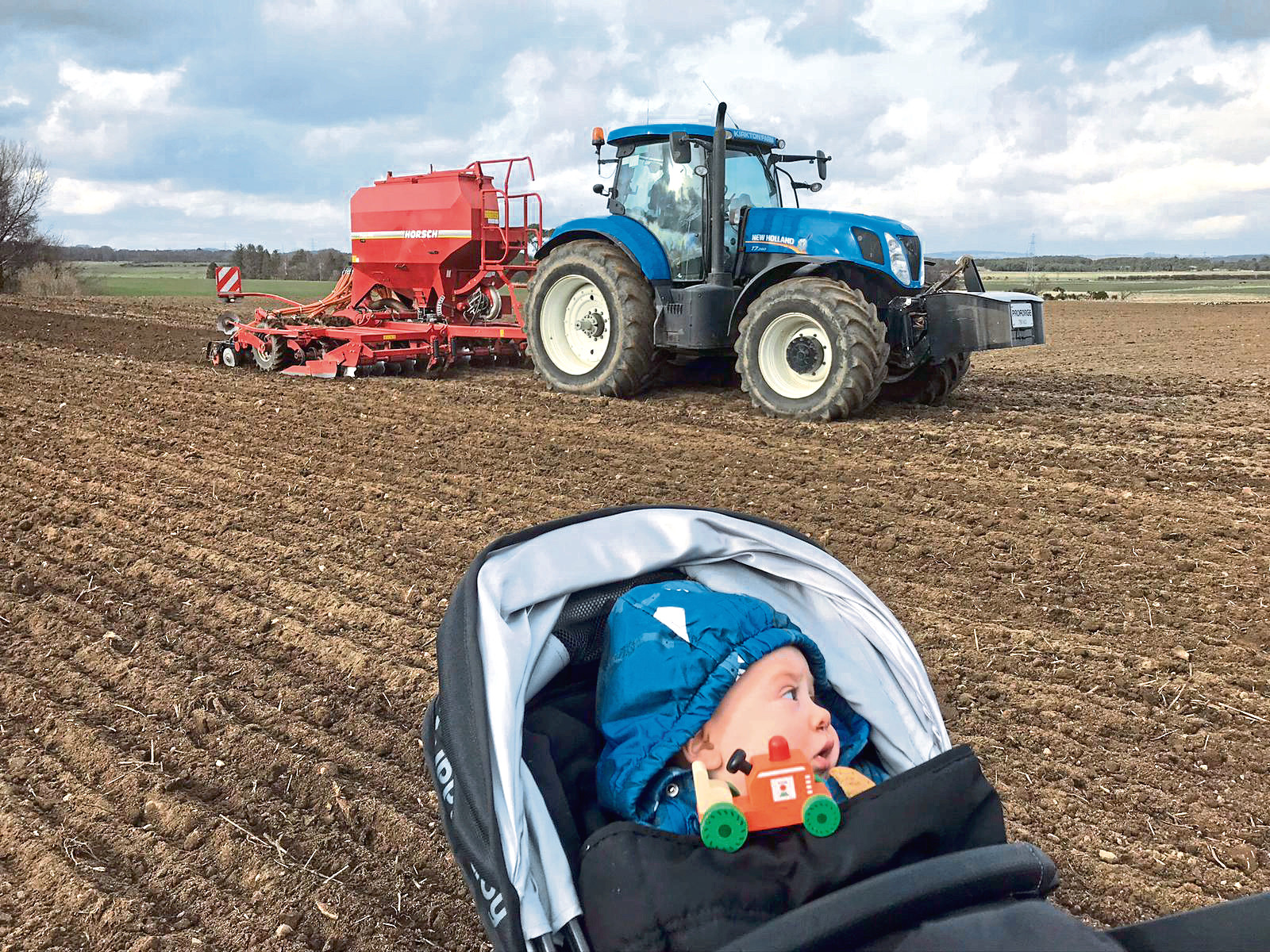 Young Blair Campbell looks on as his dad Scott gets spring crops in the ground.