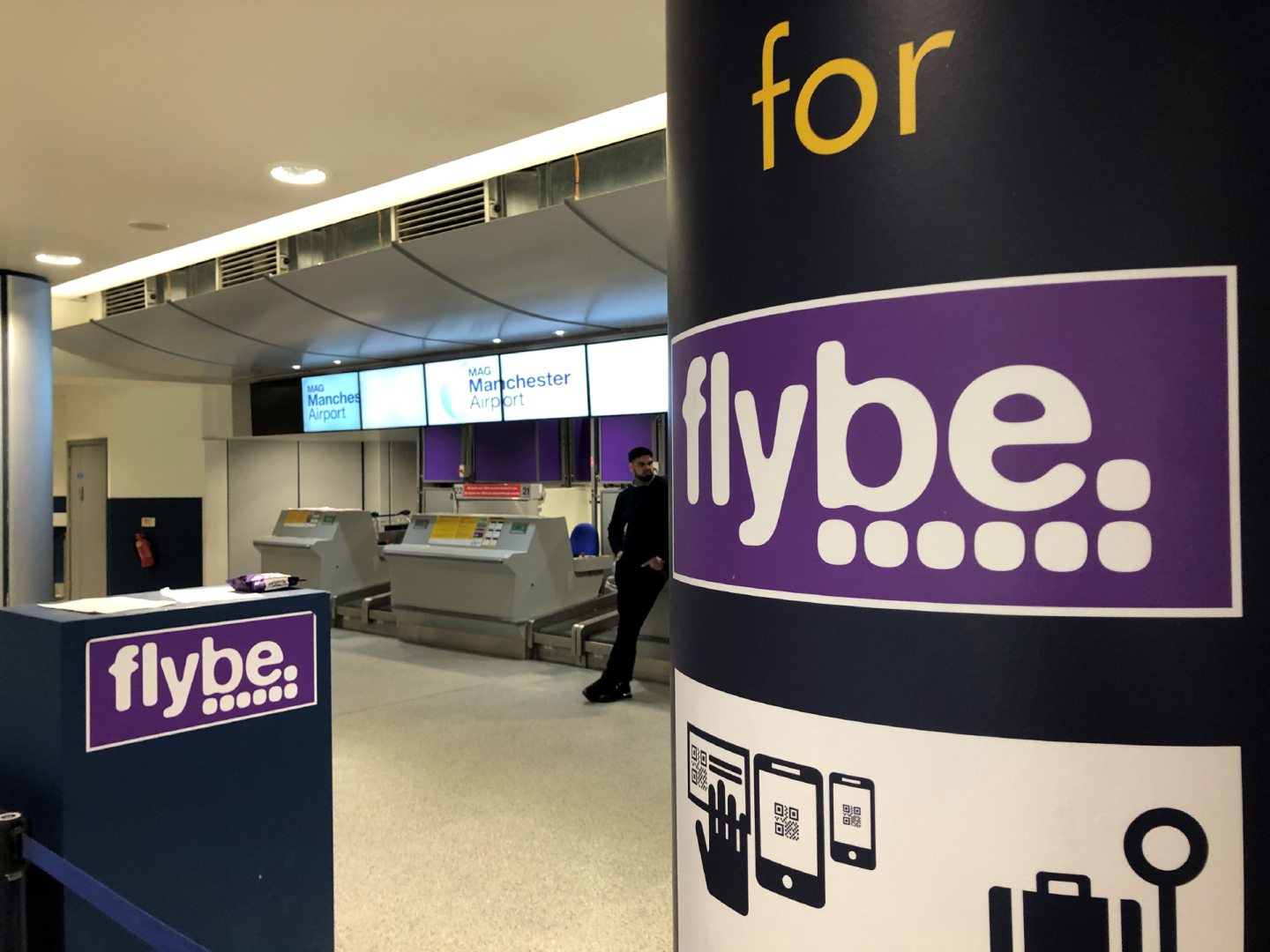 A man standing by a check-in desk at Manchester Airport as Flybe, Europe's biggest regional airline, has collapsed into administration. PA Photo. Picture date: Thursday March 5, 2020. See PA story AIR FlyBe. Photo credit should read: Pat Hurst/PA Wire