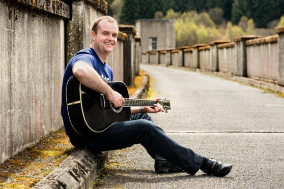 Davy Holt says the battlefield should be treated as a memorial to the fallen soliders. He is seen here playing on his guitar.