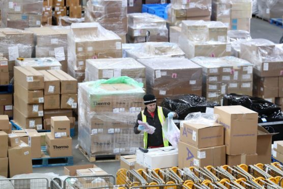 A worker gathers supplies at the NHS' national procurement warehouse at Canderside, Larkhall.