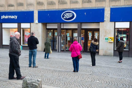 Patients wait outside Boots in Elgin town centre.