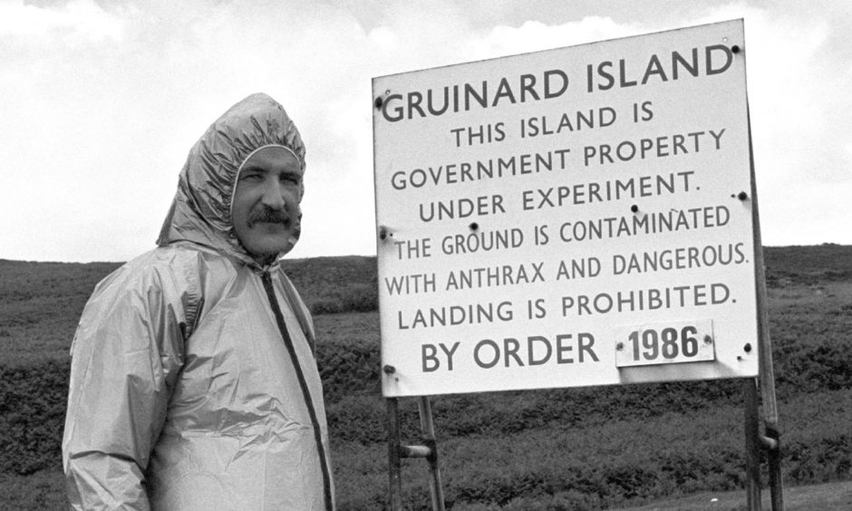Malcolm Broster of MOD Chemical Defence Establishment at Porton Down, alongside one of the warning signs on the Gruinard Island.