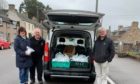 Jessie Mcdougal , trustee Willie Mcdougal and chairman Bill Malcolm out giving food bags.