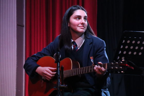 Antonia Saunders playing the guitar.