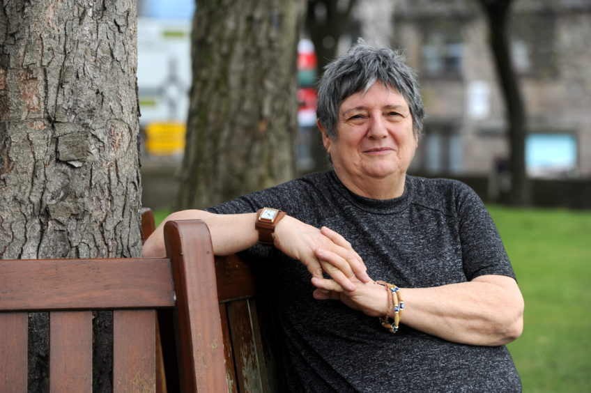 Aberdeen poet and typhoid survivor Sheena Blackhall in 2019, sitting on a bench.