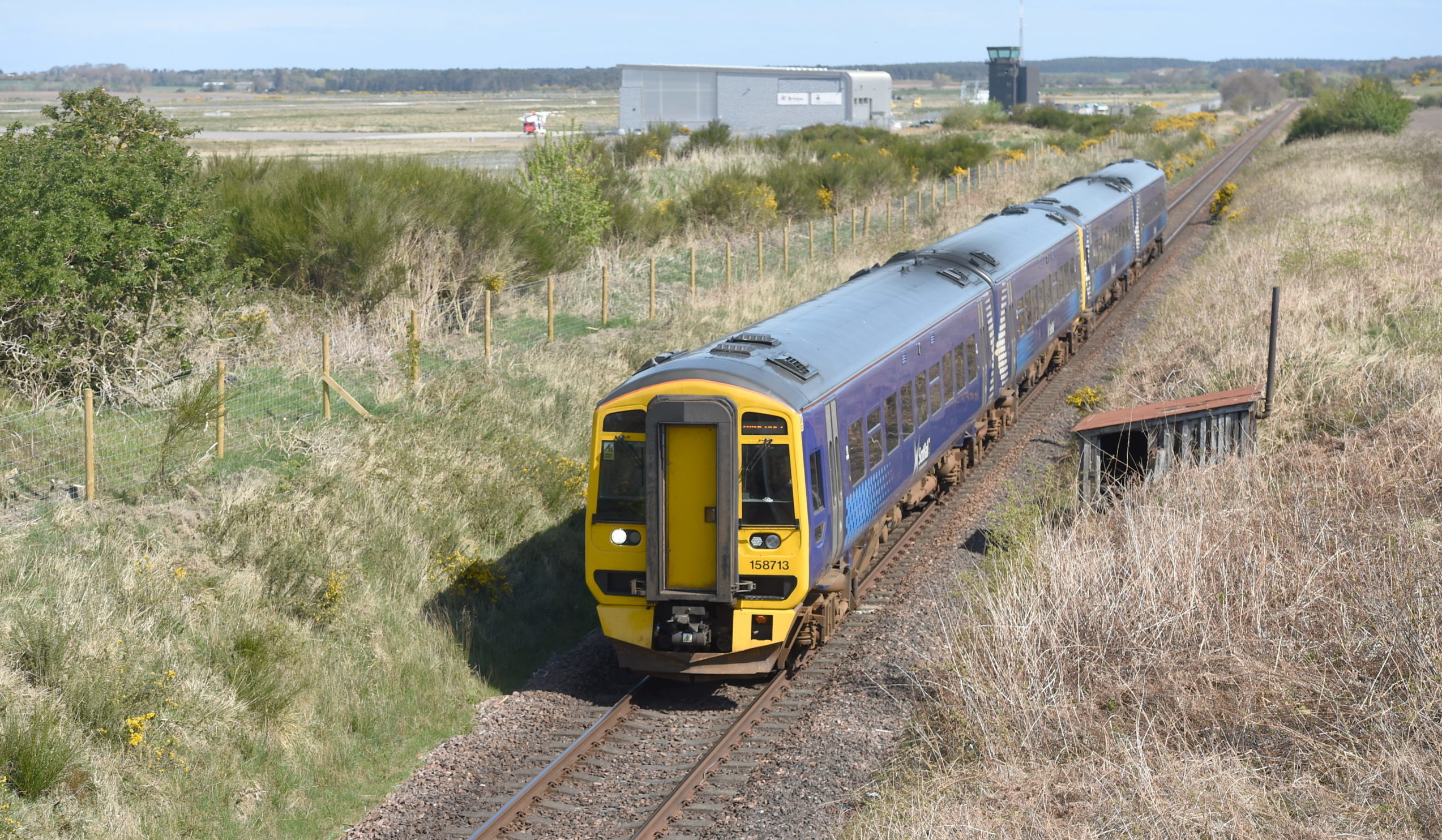 A Scotrail train on the Inverness to Aberdeen line passing the site of the proposed new railway station at Inverness Airport. Picture by Sandy McCook