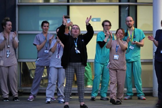Staff from the Royal Liverpool University Hospital join in a national applause during Thursday's nationwide Clap for Carers NHS initiative to applaud NHS workers fighting the coronavirus pandemic.