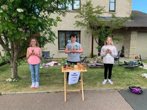 L-R: Amaia Lawrence, Scott Pert and Analeigha Lawrence selling flowerpots to raise money for the NHS.