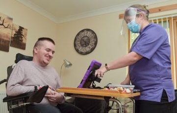 Alasdair Mason loves being connected with his sister Gillian and nephew Ben with the help of Contrast Care's Julie Flett and an i-pad. Picture by Jason Hedges