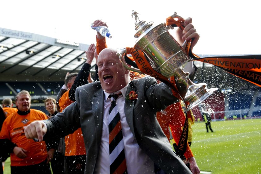 Dundee Utd manager Peter Houston celebrates with the trophy.