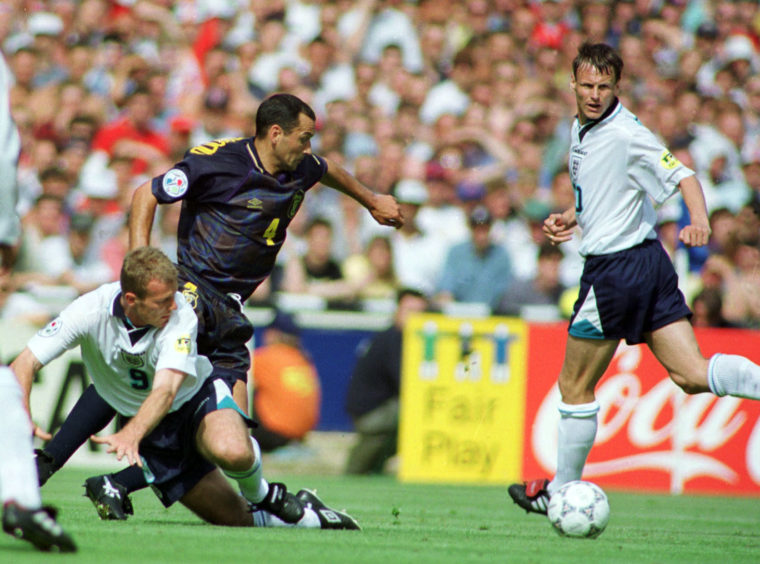 Scotland defender Colin Calderwood is challenged by Alan Shearer as Teddy Sheringham looks on.
