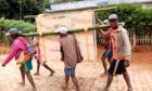A solar-powered Dulas fridge being carried by hand in Madagascar.