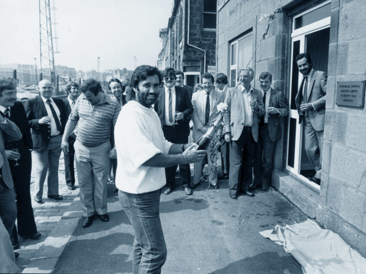 George Best about to break open a bottle of champagne to symbolise the opening of new offices for Streamline Shipping Agencies on Regent Quay in 1984.