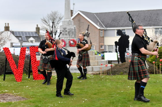 CR0021205
Pictured - Four members of the Buchan Peterson Pipe Band play at the Mintlaw war memorial for VE Day, L-R  Pamela Whyte, Kyle Elrick, Mandy Rae and Malcolm Whyte.    
Picture by Kami Thomson         08-05-2020