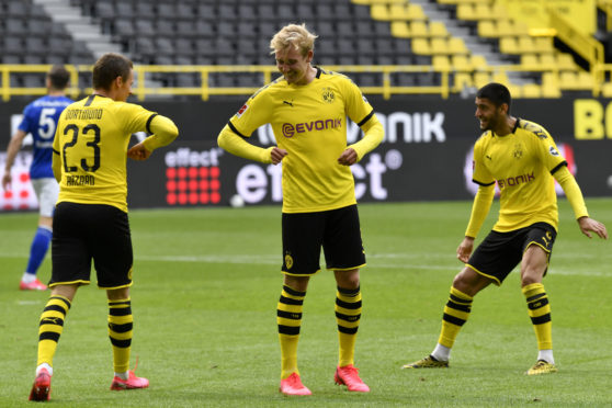 Dortmund's Thorgan Hazard, left, celebrates with Erling Haaland after scoring his side's third goal during the German Bundesliga soccer match between Borussia Dortmund and Schalke 04 in Dortmund, Germany.