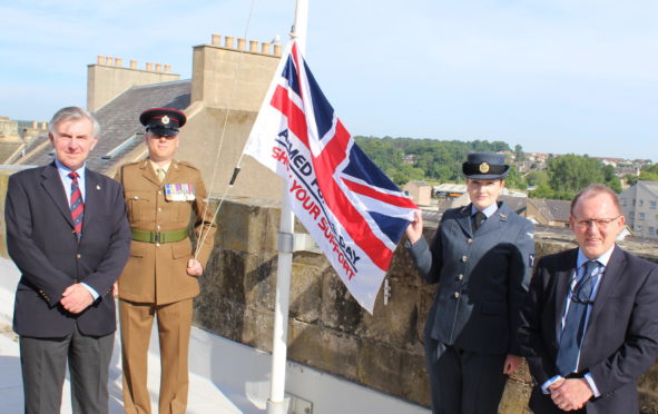 The Armed Forces Day flag is hoisted above Moray Council's headquarters.