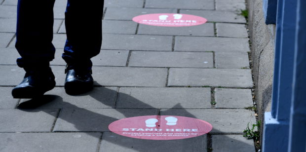 Social distancing markings on the pavement.