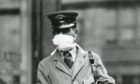 A letter carrier in New York City wearing a gauze mask to avoid catching influenza. in 1918.